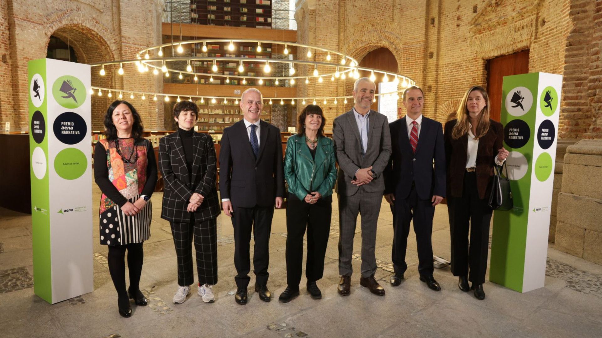  Foto de grupo de los participantes en la presentación del Premio Aena de Narrativa, de pie en la Biblioteca de las Escuelas Pías de la UNED.