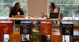 Ana Traseira, durante una entrevista de radio, tras varios cubos que simbolizan los distintos ODS