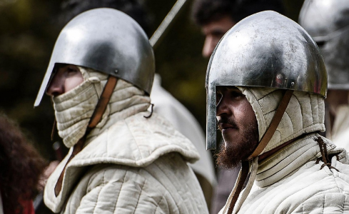 Dos hombres con casco medieval y elementos de protección